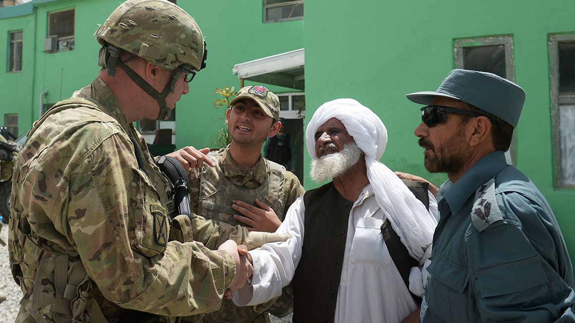 U.S. soldiers speak with Afghan locals | Photo: An Afghan interpreter translates a conversation between an American colonel and a local in Ghazni, Afghanistan; Dibyangshu Sarkar/AFP/Getty