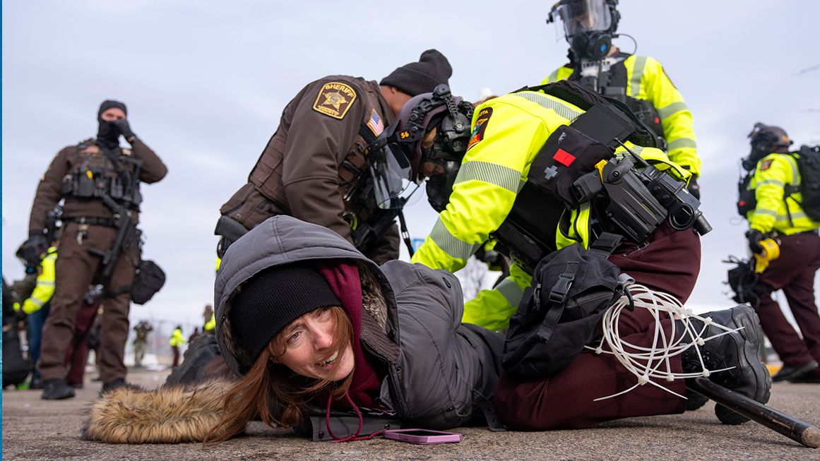 A woman being held on the ground by law enforcement officers | Photo: Whipple Building immigration protest in Minneapolis, Minnesota, in February 2026; Alex Kormann/The Minnesota Star Tribune/Getty