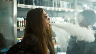 teenager blowing smoke while vaping