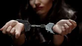 A shadowy picture of a woman in handcuffs | Motortion / Dreamstime.com