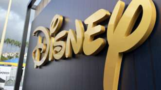 Gold Disney logo on a black background shot from a side angle