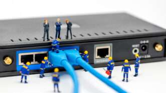 Broadband internet router with political figurines overseeing management | Kirill/Newscom