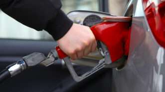 Driver pumps gas into car.