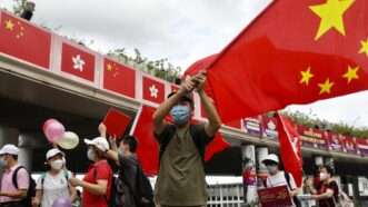 Man in waving Chinese flag at a parade. | Liau Chung-ren/ZUMAPRESS/Newscom