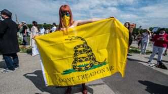Woman holding "Don't Tread on Me" flag