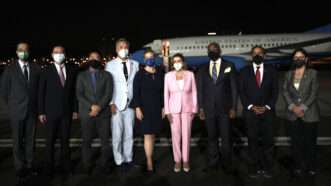 Nancy Pelosi and officials from Taiwan stand outside an American plane