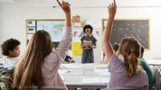 Students in a classroom raising their hands | ID 134207290 © Monkey Business Images / Dreamstime.com