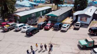 Overhead shot of a small group of people gathered in a mobile home community.