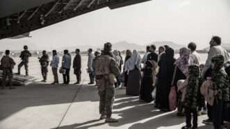 Afghan evacuees wait to board a U.S. aircraft in Kabul, Afghanistan