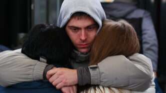 Sad Russian man hugs family during mobilization