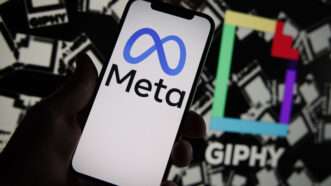 Meta logo on a phone and giphy logo in the background behind | Jaap Arriens/Sipa USA/Newscom