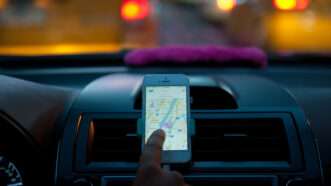 Rideshare driver pointing at map app