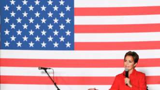 Republican candidate for Arizona governor Kari Lake, dwarfed by an American flag. | Alexandra Buxbaum/Sipa USA/Newscom