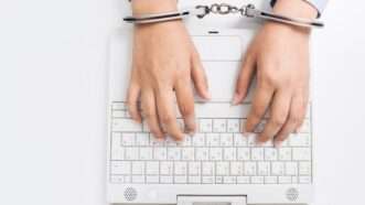 Typing in handcuffs | Carolannefreeling / Dreamstime.com