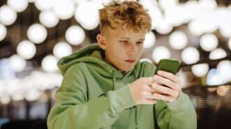 teenage boy looking at a cell phone