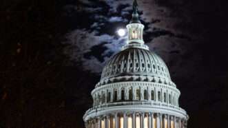 capitol rotunda at night under moon and clouds