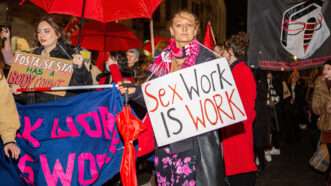 sex worker rights protest with people holding signs that say "FOSTA SESTA has a body count" and "sex work is work"