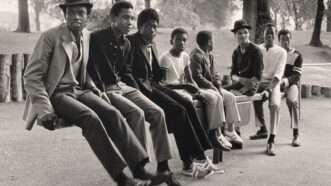African American men sitting on benches in a photograph in Great Britain | Vanley Burke, Young Men on See-Saw, Handsworth Park, Birmingham, 1984, printed 2021, gelatin silver print, Alfred H. Moses and Fern M. Schad Fund, 2022.112.1