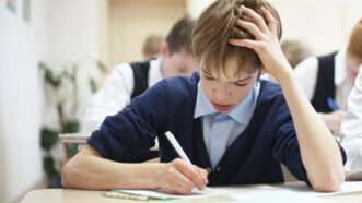 A male student struggles while taking a test. | Rimma Zaytseva | Dreamstime.com