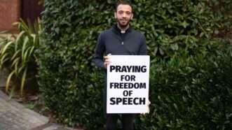 A man holding a sign reading "Praying for Free Speech" | ADF UK