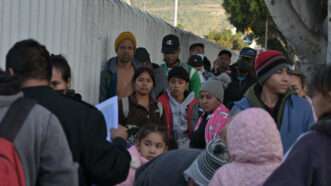 Migrants wait in line at the U.S.-Mexico border