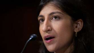 FTC Chairwoman Lina Khan speaks into a microphone against a black background. | Graeme Sloan/Sipa USA/Newscom