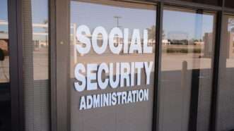 A storefront with the blinds closed, with "SOCIAL SECURITY ADMINISTRATION" stenciled onto the glass in white letters.