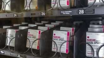 Boxes of Narcan naloxone spray behind glass in a vending machine. | imageBROKER/Jim West/Newscom