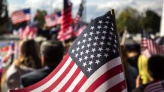 crowd of people waving American flags | Photo by <a href="https://unsplash.com/@ninjason?utm_source=unsplash&utm_medium=referral&utm_content=creditCopyText">Jason Leung</a> on <a href="https://unsplash.com/images/travel/america?utm_source=unsplash&utm_medium=referral&utm_content=creditCopyText">Unsplash</a>   