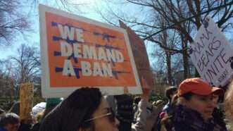 March for Our Lives protesters hold up a sign that says "WE DEMAND A BAN" | Erin Alexis Randolph | Dreamstime.com