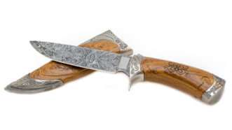 Wood-handled knife with a wooden scabbard, with an ornate pattern imprinted into the blade. | Nejron | Dreamstime.com