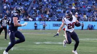 A Houston Texans player runs with the football, trying to evade a Tennessee Titans player. | Matthew Maxey/Icon Sportswire DHH/Matthew Maxey/Icon Sportswire/Newscom