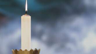 A lit candle used in a Catholic mass. | Jekaterina Voronina | Dreamstime.com