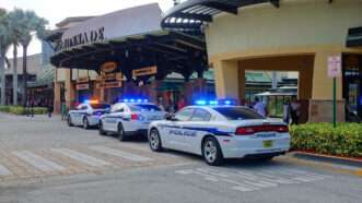 Police cars lined up in front of a mall. | Jillian Cain | Dreamstime.com