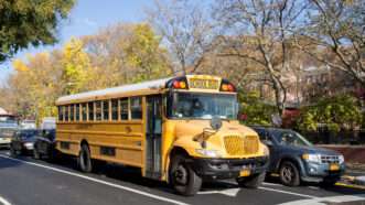 A yellow school bus sits in traffic. | Oliver Foerstner | Dreamstime.com