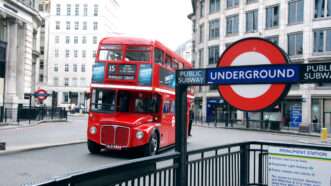 A red double-decker bus passes an Underground sign in London. | Stuart Pearcey | Dreamstime.com