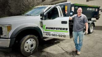 Steven Hedrick stands by his truck, labeled X Dumpsters, that he uses to transport Dumpsters. | Goldwater Institute