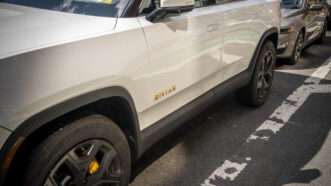A white Rivian R1S all-electric SUV sits parked on the street in New York City. | Richard B. Levine/Newscom