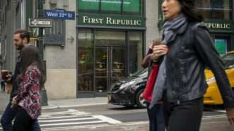 people walking by a branch of First Republic Bank