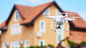 A camera-mounted drone flying in a residential area. | Dmitry Kalinovsky | Dreamstime.com