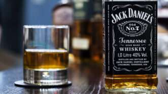 Bottle of Jack Daniel's next to a half full whiskey glass | Igor Golovniov/ZUMA Press/Newscom