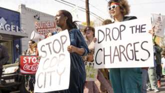 Anti-"Cop City" protesters hold signs that say STOP COP CITY and DROP THE CHARGES | Steve Eberhardt/ZUMAPRESS/Newscom