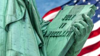 A close-up on the "JULY IV MDCCLXXVI" inscription held by the Statue of Liberty.