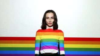 young woman in rainbow flag sweater | Photo by <a href="https://unsplash.com/@isiparente?utm_source=unsplash&utm_medium=referral&utm_content=creditCopyText">Isi Parente</a> on <a href="https://unsplash.com/photos/ReeGI822YKM?utm_source=unsplash&utm_medium=referral&utm_content=creditCopyText">Unsplash</a>   