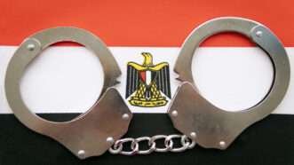 A pair of handcuffs against the backdrop of the Egyptian flag. | Dmitrii Melnikov | Dreamstime.com