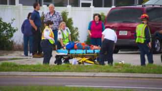 Paramedics transport an injured man on a gurney. | Mike2focus | Dreamstime.com