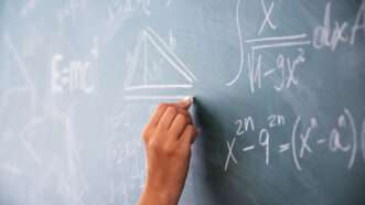 Hand writing math calculations on a chalkboard | erika8213/Newscom