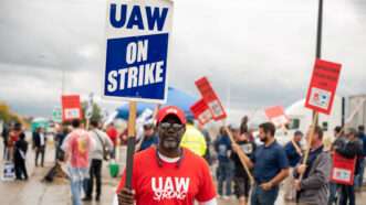 A member of the United Auto Workers (UAW) union holds a sign saying "UAW ON STRIKE" outside a Ford plant in Wayne, Michigan. | Matthew Rodier/Sipa USA/Newscom