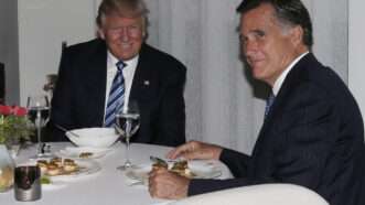 Donald Trump sits at a meal around the table with Mitt Romney | Polaris/Newscom