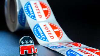 An enamel pin of the Republican Party's elephant symbol next to a roll of "I VOTED TODAY" stickers | Joaquin Corbalan | Dreamstime.com